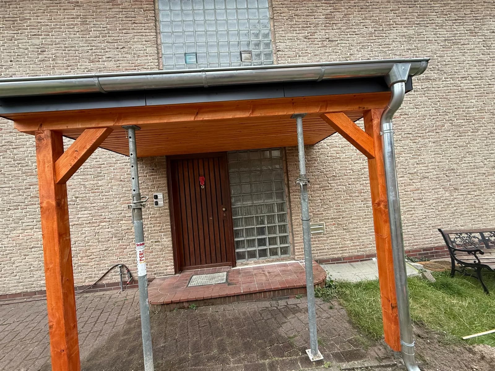 Fertige Eingangsüberdachung mit lasierten Holzstützen und EPDM-Abdichtung