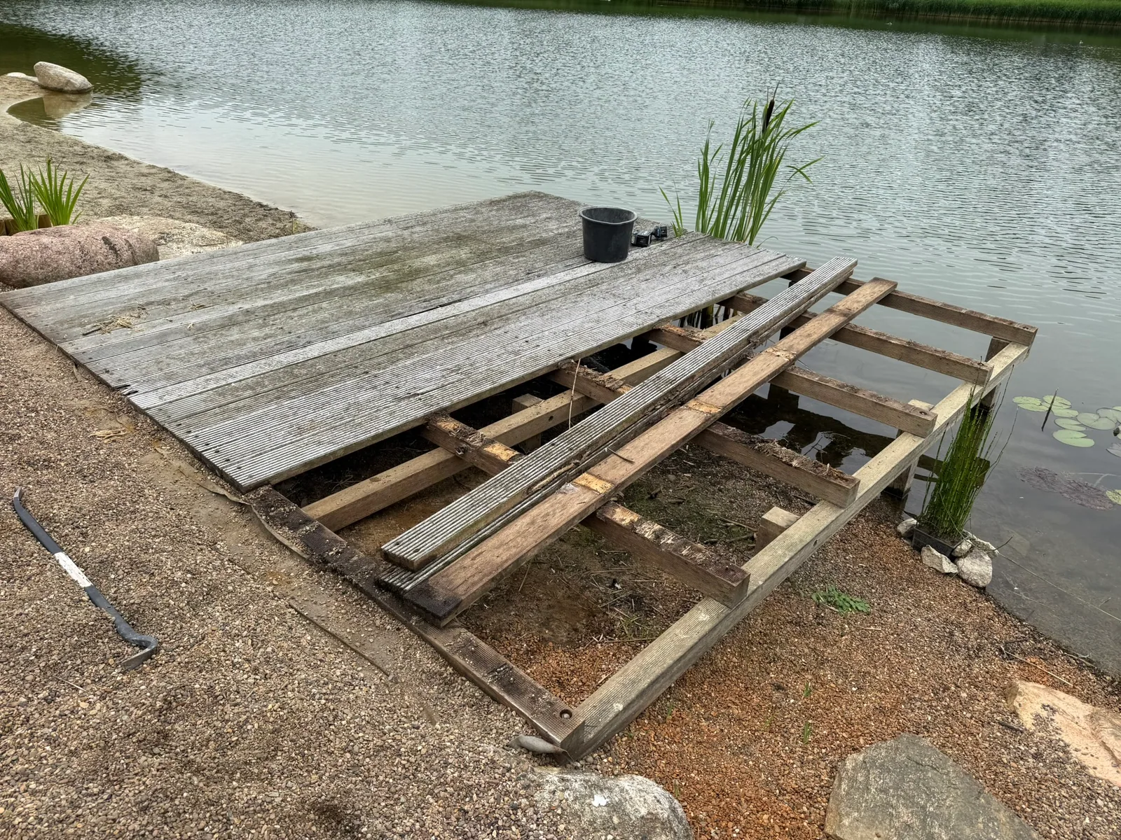 Verwitterte, morsche Holzplattform am Seeufer vor dem Rückbau